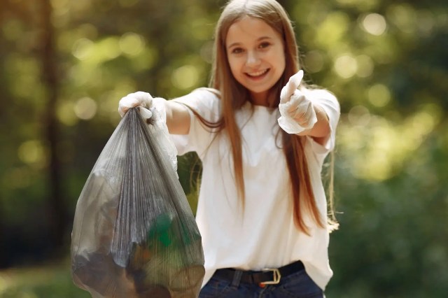 A girl collecting litter during eco-friendly activities for students.