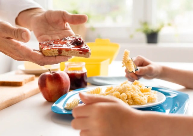 balanced-diet-for-students Child eating pasta, apple and toast as part of balanced diet for students.