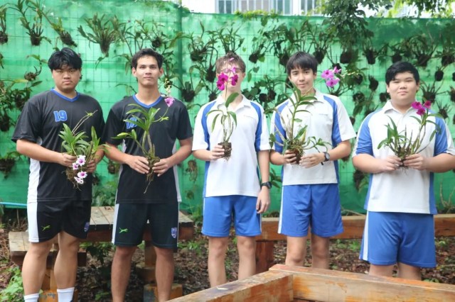 Students holding plants during an outdoor activity, reflecting the Green Valley Experiential Learning Award.