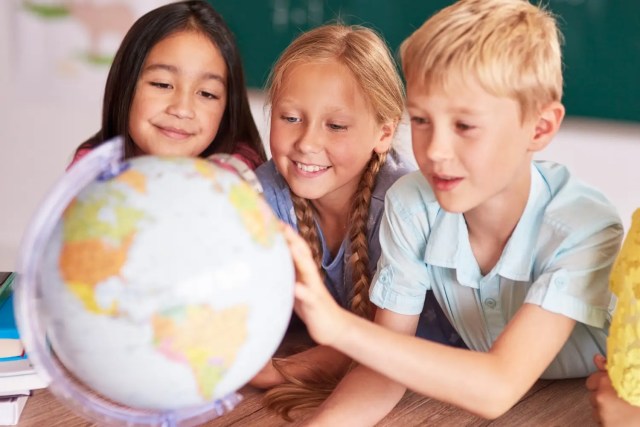 global-perspective-in-education Children exploring a globe together while developing a global perspective in education.