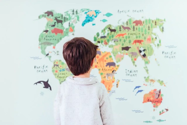 global-perspective Child observing a world map while developing global perspective and cultural awareness.