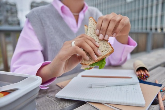 healthy-snacks-for-students Student eating a wholegrain sandwich, one of healthy snacks for students.