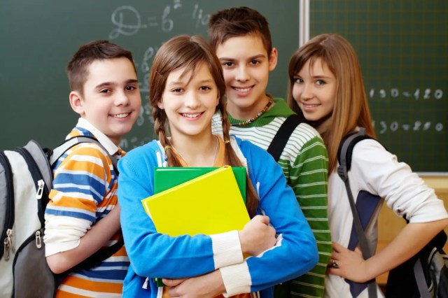 leadership-skills-for-students Confident student leaders smiling in a classroom, highlighting student leadership development.