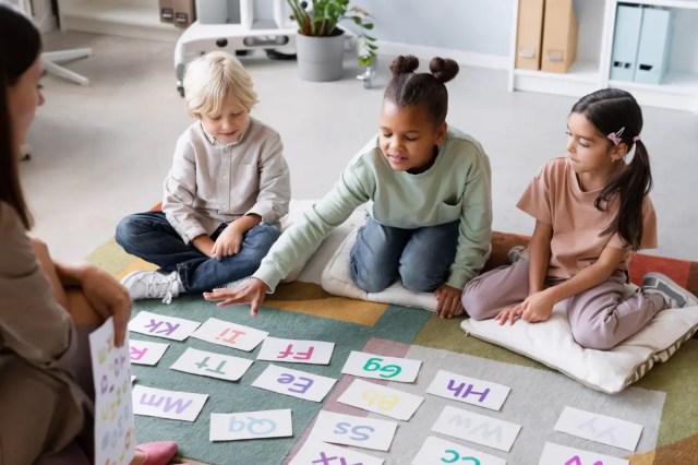 Children taking part in play-based learning activities with alphabet cards.