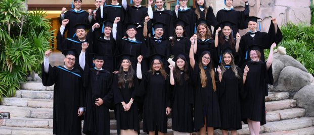 Group of St. Andrews international school alumni in graduation gowns celebrating their achievements before beginning global careers and studies