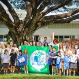a group of students and teachers celebrating the school’s Green flag award for their eco-school