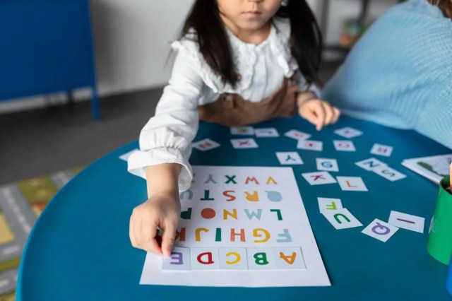 third-language Child learning a third language with alphabet cards.