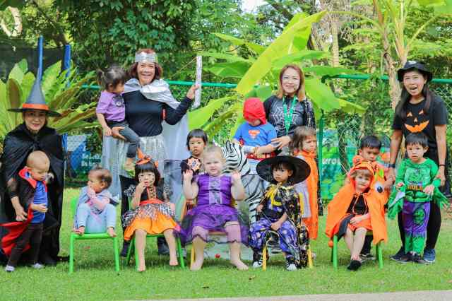 colorful-costumes-at-school Young children,parents, and teachers in colourful costumes at a school event, showing community sense in early education.