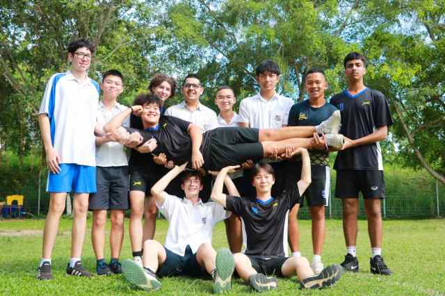 demonstrating-teamwork A diverse group of students at St. Andrews Green Valley holds up a peer demonstrating teamwork and trust.