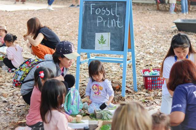 eco-school-for-early-years Young children at St. Andrews Green Valley create fossil prints with leaves during outdoor sustainability activities, learning environmental care through hands-on exploration in eco school for early years