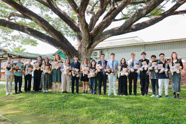 futures-worldwide IB Class of 2025 graduates at Green Valley holding bears and flowers, ready to pursue diverse futures worldwide
