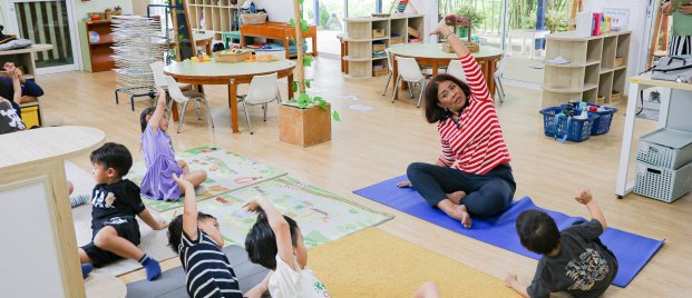 Teacher leads kids in fun stretching, showing how simple mental health activities for students boost focus and wellbeing.
