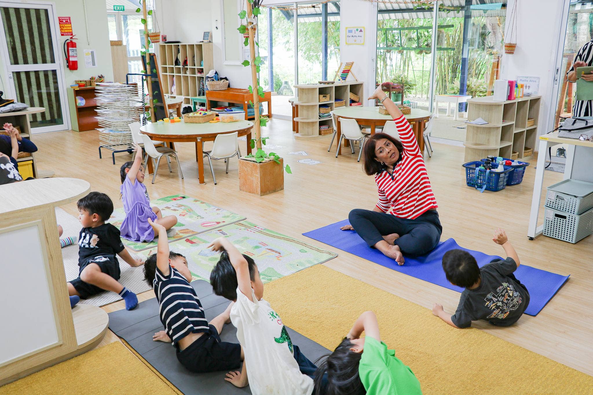 mental-health-activities Teacher leads kids in fun stretching, showing how simple mental health activities for students boost focus and wellbeing.