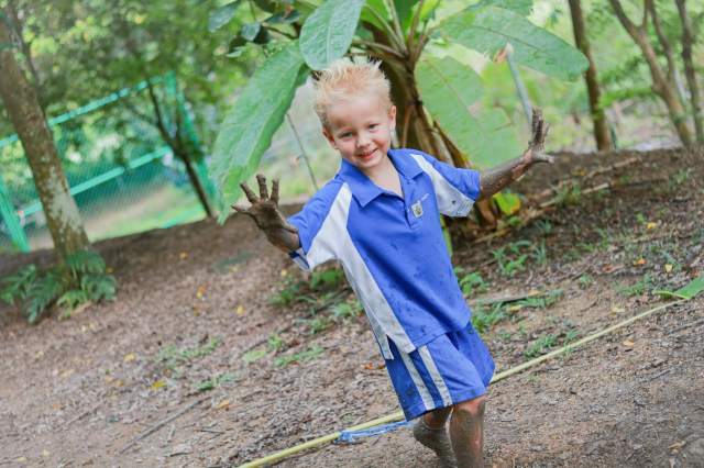 A Forest School student at St. Andrews Green Valley confidently explores muddy play, developing sensory awareness, independence, and emotional resilience through child-led learning in a natural forest environment.