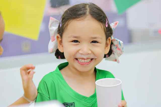 well-maintained-student-well-being Green Valley student smiles with happiness while eating her ice cream, displaying well-maintained students' wellbeing