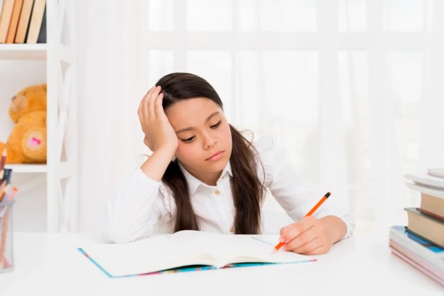 MLD-in-student Girl showing signs of MLD in students while struggling with writing tasks.