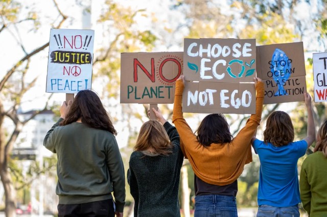 sustainability Students holding environmental protest signs promoting sustainability.