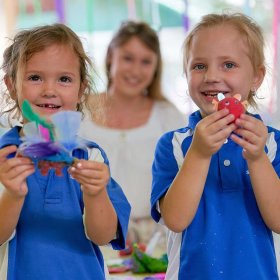 girls show toys that they made in class